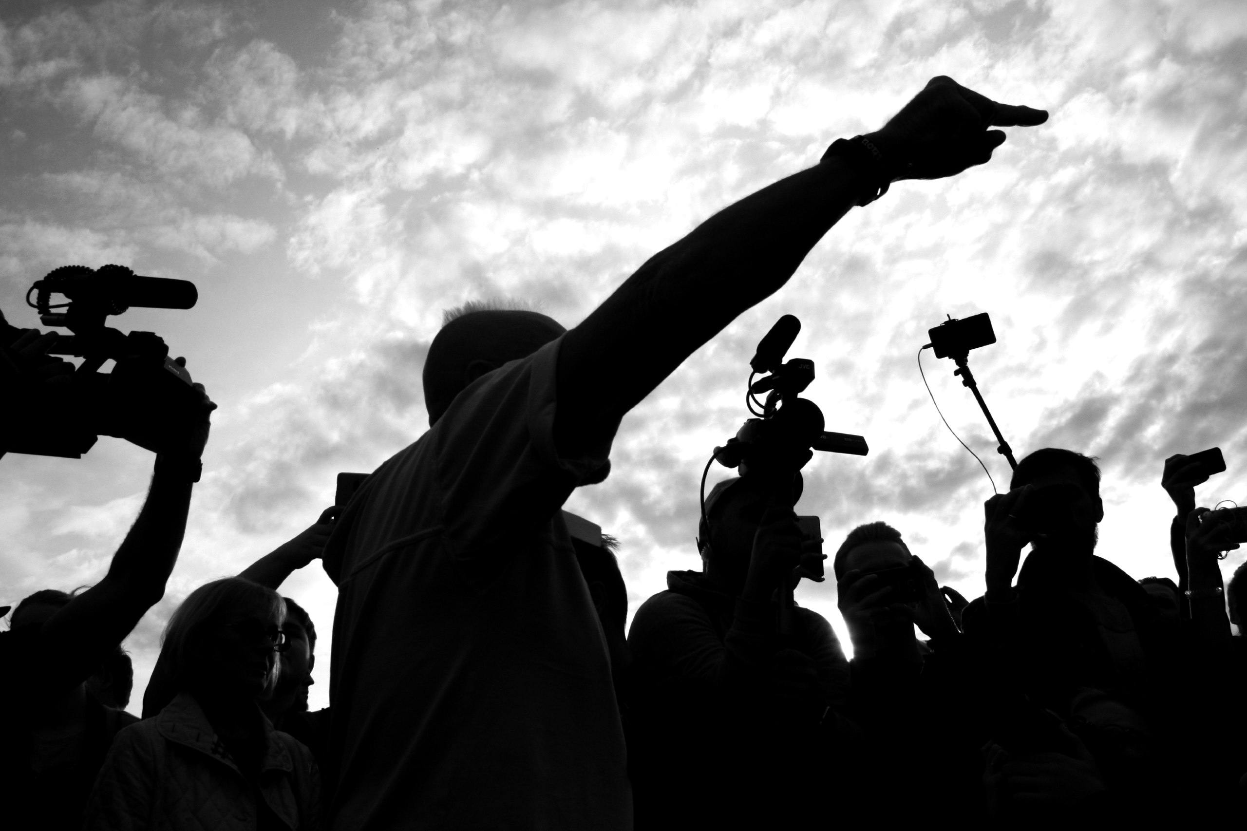 silhouette of reporters with cameras and microphones